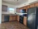 A functional kitchen featuring modern black appliances and wooden cabinetry at 2324 W Luke Ave, Phoenix, AZ 85015