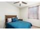 Bedroom with teal bedding, wooden nightstand, and ceiling fan at 2427 W Kowalsky Ln, Phoenix, AZ 85041