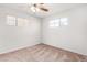 Neutral bedroom with ceiling fan, two windows and carpet flooring, offering a cozy and comfortable atmosphere at 2906 W Alice Ave, Phoenix, AZ 85051