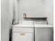 Convenient laundry area with a white washer and dryer, shelf and plenty of space for laundry tasks at 2906 W Alice Ave, Phoenix, AZ 85051