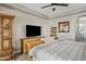 Bright bedroom featuring a television, wooden furniture, and ceiling fan at 3021 E Agritopia N Loop, Gilbert, AZ 85296