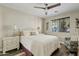 Serene main bedroom featuring a comfortable bed, wood floors, ceiling fan, and large window for ample natural light at 3021 E Agritopia N Loop, Gilbert, AZ 85296