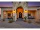 Elegant entryway with arched doorway and lush landscaping at 30416 N 64Th St, Cave Creek, AZ 85331