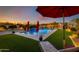 Relaxing pool area with red umbrellas and lush green landscaping at 30416 N 64Th St, Cave Creek, AZ 85331