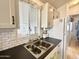 Clean and functional kitchen with white cabinets, subway tile, and stainless steel sink at 356 S Felspar Dr, Apache Junction, AZ 85119