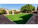 Landscaped backyard featuring artificial turf and stone pathways at 4220 E Thistle Landing Dr, Phoenix, AZ 85044