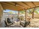 Back patio with a covered seating area, a dining table, and a large backyard with plants at 4903 W Palm Ln, Phoenix, AZ 85035