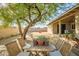 Backyard featuring a covered patio, mature tree, and a dining table in a serene outdoor setting at 4903 W Palm Ln, Phoenix, AZ 85035