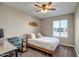 Cozy bedroom featuring a bed, work desk, natural light from the window and a ceiling fan at 4903 W Palm Ln, Phoenix, AZ 85035