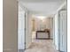 Bright hallway with neutral walls, tiled floor, console table, and open doorways to bedrooms and bathroom at 4903 W Palm Ln, Phoenix, AZ 85035