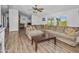 Living room with L-shaped sofa, wood-look floors, and a ceiling fan at 49201 N 24Th Ave, New River, AZ 85087