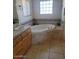 This bathroom boasts a tiled, jetted tub with neutral tile and a window at 55823 N 329Th Dr, Wickenburg, AZ 85390