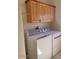 Laundry room featuring a washer and dryer set and wood cabinets above at 55823 N 329Th Dr, Wickenburg, AZ 85390