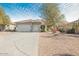 Two-car garage and welcoming front yard with mature trees at 5613 N Laguna Ct, Litchfield Park, AZ 85340