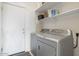 Convenient laundry room with washer, dryer, and shelving at 5613 N Laguna Ct, Litchfield Park, AZ 85340