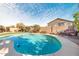 Inviting kidney-shaped pool with patio and grassy area at 5613 N Laguna Ct, Litchfield Park, AZ 85340