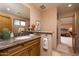 Bathroom with granite vanity, wood cabinets, and a view of the bedroom at 8502 E Country Club Trl, Scottsdale, AZ 85255