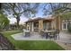 An inviting backyard with a covered patio, dining, outdoor seating, and well-manicured synthetic lawn at 9837 E Pershing Ave, Scottsdale, AZ 85260