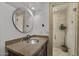 Bright bathroom featuring stone countertop, round mirror, and glass shower at 9837 E Pershing Ave, Scottsdale, AZ 85260