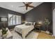 Comfortable bedroom with dark walls, a ceiling fan, plantation shutters, and natural lighting at 9837 E Pershing Ave, Scottsdale, AZ 85260