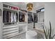 Spacious walk-in closet with custom shelving and an island ottoman at 9837 E Pershing Ave, Scottsdale, AZ 85260