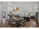 Open dining area featuring a wooden table, pendant lights, neutral decor, and a view into the adjacent kitchen at 9837 E Pershing Ave, Scottsdale, AZ 85260