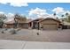 Charming single-story home with a tile roof, desert landscaping, and a brick-paved driveway leading to an attached two-car garage at 9837 E Pershing Ave, Scottsdale, AZ 85260