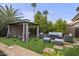 Backyard gazebo with outdoor seating and a firepit, surrounded by lush landscaping and green lawn at 9837 E Pershing Ave, Scottsdale, AZ 85260