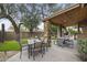 An outdoor patio featuring a dining area, stone columns, and a covered seating area for entertaining at 9837 E Pershing Ave, Scottsdale, AZ 85260