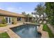 A serene backyard features a pool, landscaped greenery, and lounge area for relaxation and outdoor enjoyment at 9837 E Pershing Ave, Scottsdale, AZ 85260