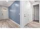 Light and airy entryway with wood-look floors and blue accent wall at 10012 E Tamery Ave, Mesa, AZ 85212