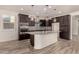Modern kitchen with dark cabinets, granite countertops, and island at 10012 E Tamery Ave, Mesa, AZ 85212