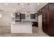 Modern kitchen with dark cabinets, granite countertops, and island at 10012 E Tamery Ave, Mesa, AZ 85212