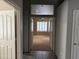 Open hallway with tile flooring leading to a carpeted room with plantation shutters at 1022 E Hiddenview Dr, Phoenix, AZ 85048