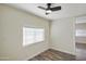 Small bedroom with a ceiling fan, wood-look floors, and a bright window providing natural light at 104 N 114Th St, Apache Junction, AZ 85120