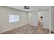An empty bedroom with a modern ceiling fan, wood-style flooring, and an ensuite bathroom at 104 N 114Th St, Apache Junction, AZ 85120