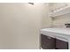 Convenient laundry area features a modern washing machine and storage shelves, maximizing functionality at 10401 N Saguaro Blvd # 210, Fountain Hills, AZ 85268