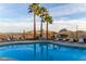 Community pool offers mountain views, lounge seating, and tropical palm trees, perfect for relaxation at 10401 N Saguaro Blvd # 210, Fountain Hills, AZ 85268
