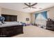 Bedroom with a large bed, ceiling fan, and ample natural light from the window at 11971 W Granada Rd Rd, Avondale, AZ 85392