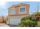 Two-story, peach colored home with red tile roof, front-facing two-car garage, and desert landscape at 11971 W Granada Rd Rd, Avondale, AZ 85392