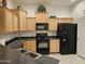 Well-lit kitchen featuring black appliances, wooden cabinets, and a functional layout at 14575 W Mountain View Blvd # 11210, Surprise, AZ 85374