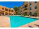 Inviting community pool with surrounding lounge chairs and apartment building views at 14575 W Mountain View Blvd # 11210, Surprise, AZ 85374