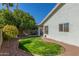 Charming backyard featuring green lawn, lush trees, and exterior of the house at 1582 W Chicago St, Chandler, AZ 85224