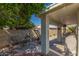 The covered patio offers shaded seating, a grill and view of the lush backyard at 1582 W Chicago St, Chandler, AZ 85224