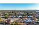 High-angle aerial view of the residential area showcasing tree-lined streets and diverse home styles under a clear sky at 1708 W Harmont Dr, Phoenix, AZ 85021