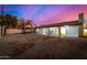 Spacious backyard at twilight with a covered patio and ample space for entertaining at 1708 W Harmont Dr, Phoenix, AZ 85021