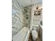 Bathroom featuring tub with marble-like tile surround, shower, stylish vanity, and decorative storage cabinet at 1708 W Harmont Dr, Phoenix, AZ 85021