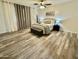Inviting bedroom featuring wood floors, a ceiling fan, and a cozy bed with decorative pillows and linens at 1708 W Harmont Dr, Phoenix, AZ 85021