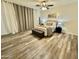 Comfortable bedroom featuring light colored walls, wood floors, and an overhead fan and light combo at 1708 W Harmont Dr, Phoenix, AZ 85021