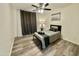 Simple bedroom with wood floors, an overhead fan and light combo, and a black metal bed frame at 1708 W Harmont Dr, Phoenix, AZ 85021